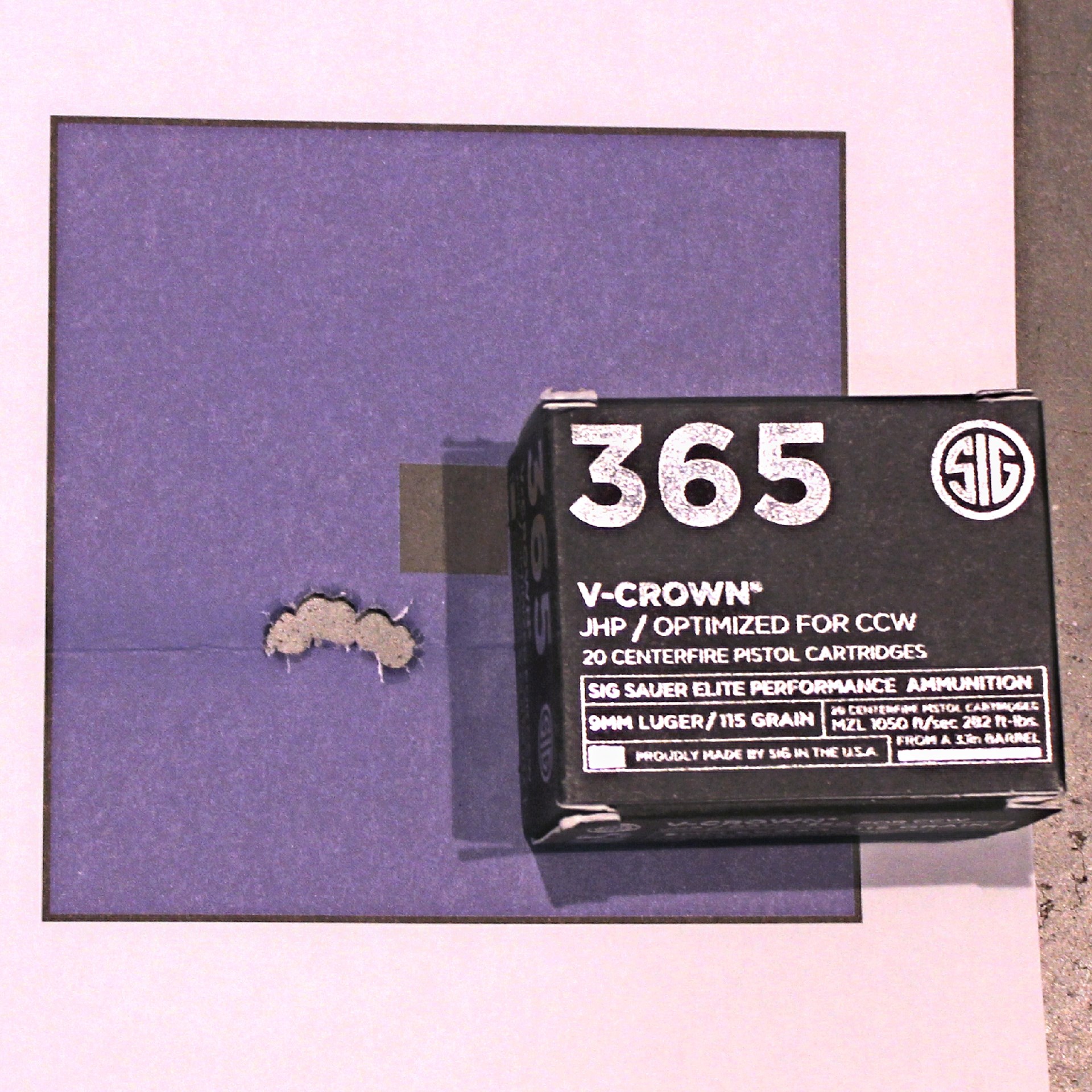 SIG Sauer box ammunition shown with target and 9 mm accuracy group cluster holes