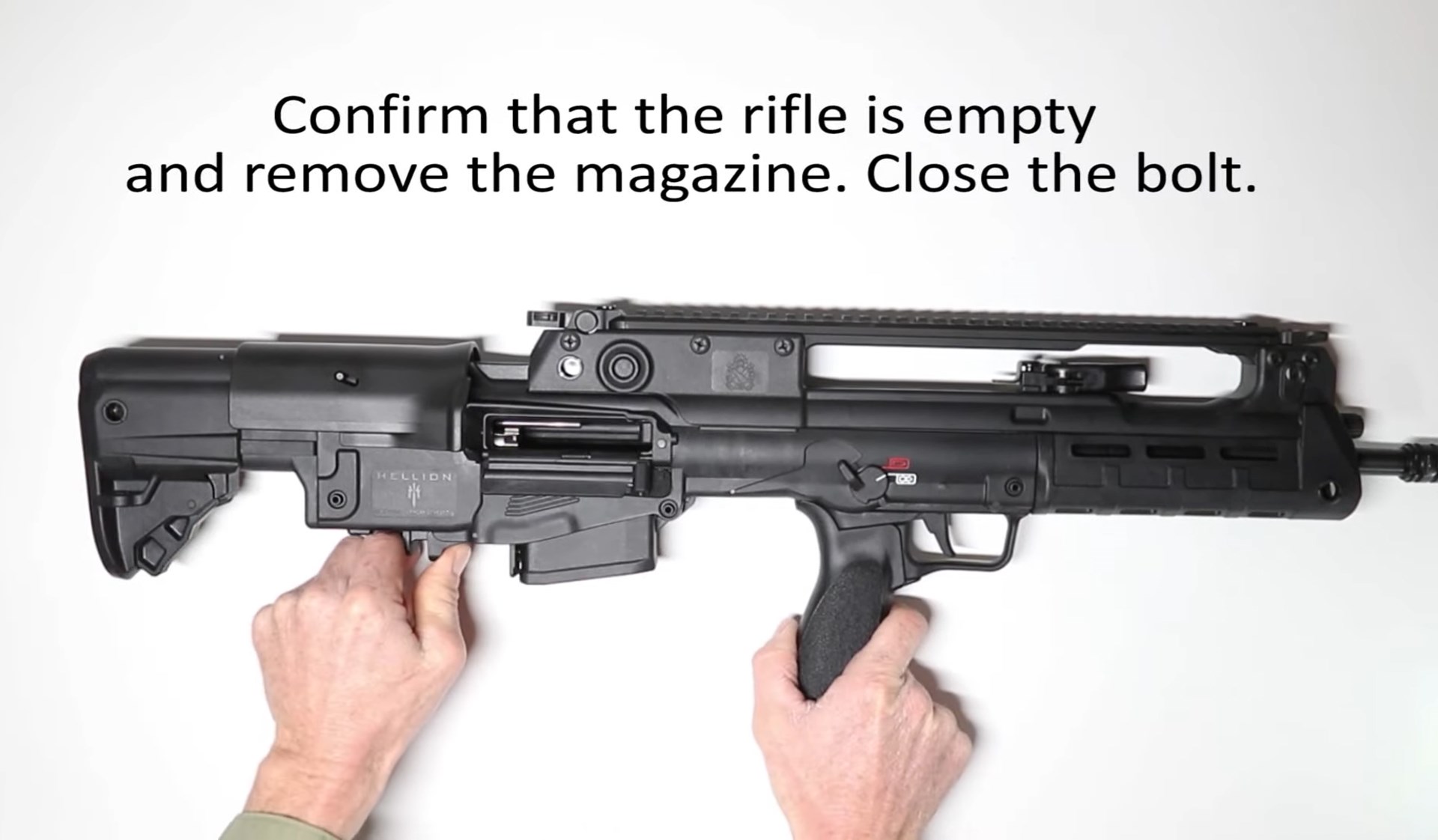 Video screenshot of white table with black springfield armory hellion bullpup rifle right-side view text on image describing safety and procedure disassembly