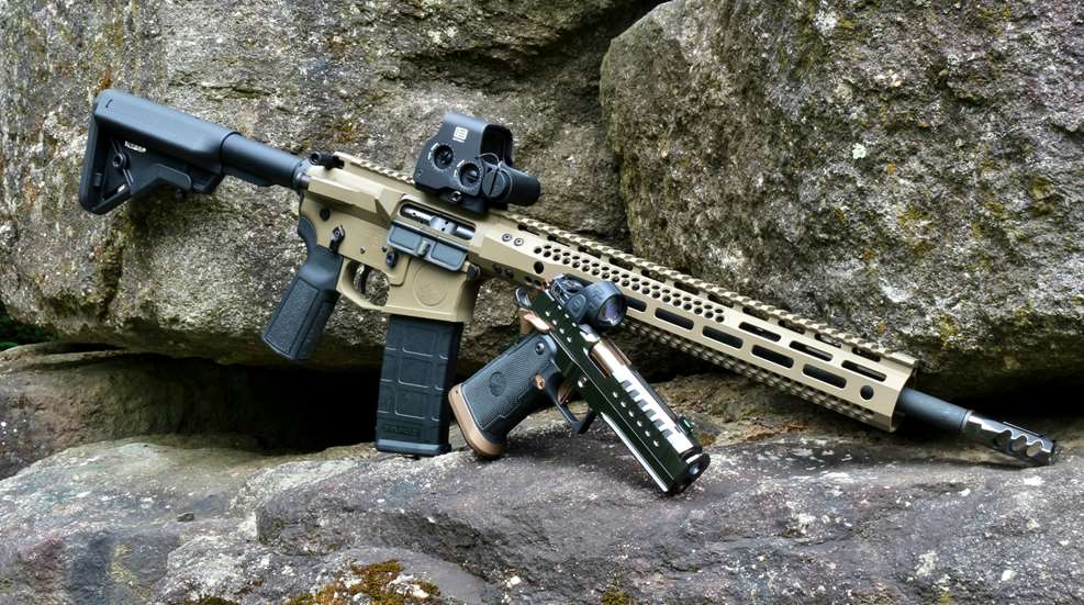 Watchtower Firearms Type 15 semi-automatic rifle with flat dark earth color treatment shown outdoors on boulders alongside apache pistol double-stack 1911