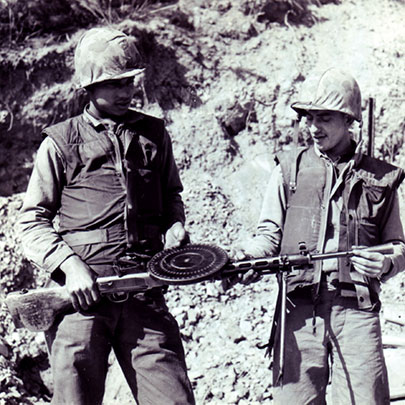 Marines examine a DP-27 light machine gun. The DP-27 weighed 25 lbs. loaded and had a cyclic rate of 550 rounds-per-minute.