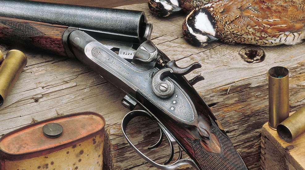Left-side view side-by-side shotgun on wood table with quail birds ammunition