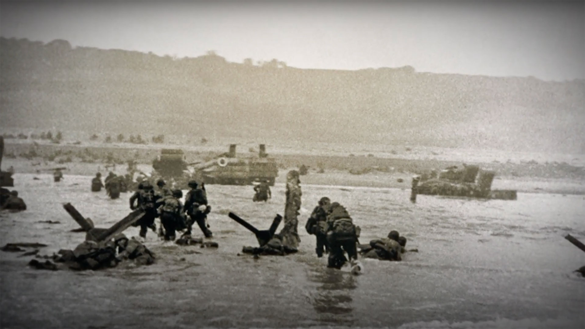 Men wading ashore at Omaha, with a clearer picture of the scene of chaos unfolding on the beach.
