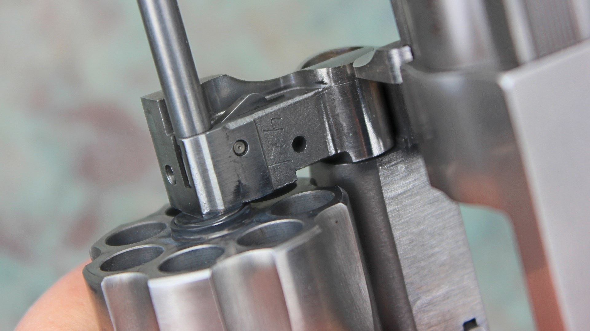 Ruger GP-100 stainless steel revolver yoke detail gun part close-up cylinder metal stamping lockup