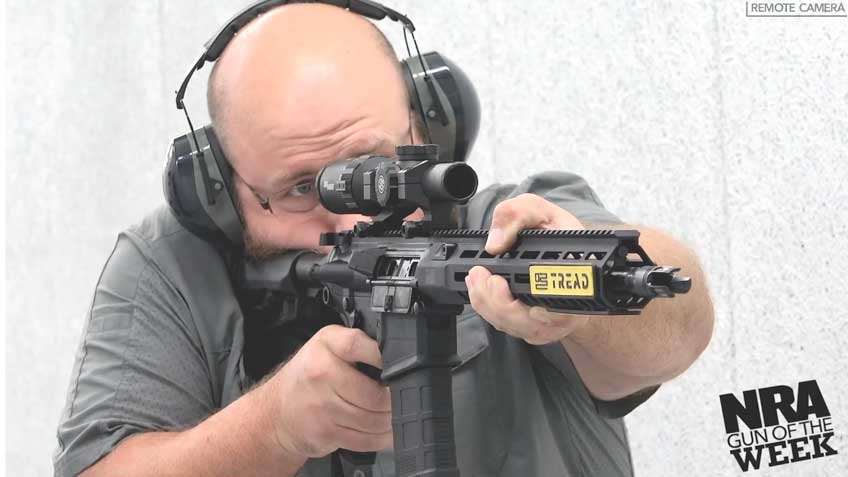 Man ear muff rifle shooting indoors white background