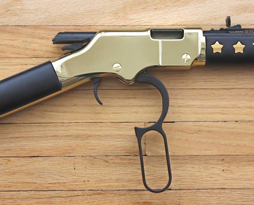 Henry Golden Boy Texas Tribute with lever action open on a wood background.