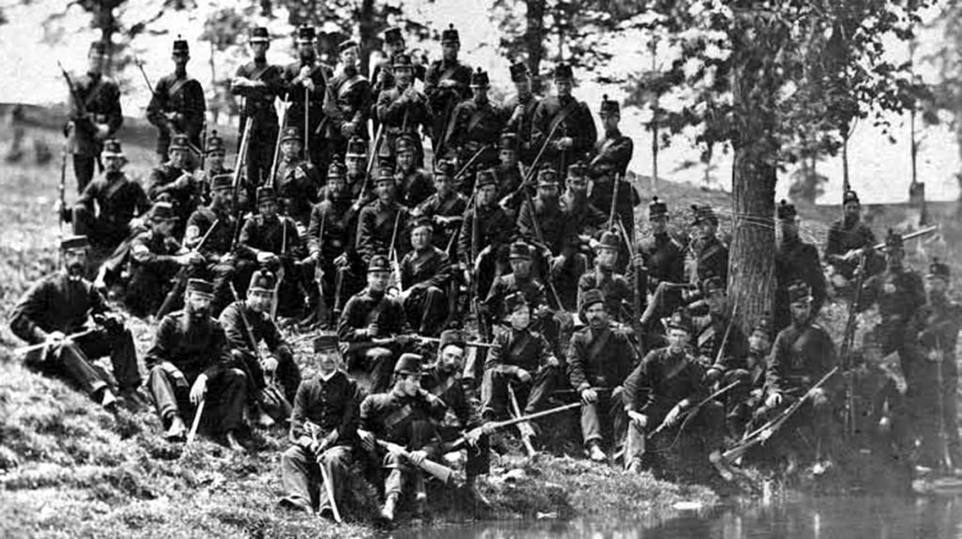 Members of Number 5 Company, Queen’s Own Rifles (2d Battalion, Canadian Militia) pose after the Battle of Ridgeway. The unit’s founder, Lieutenant Colonel William Smith Drurie, may be the officer (with the mustache and side whiskers) seated between the two surviving company officers. At the time, Drurie was the Assistant Adjutant General for Canada.  Note the mix of Spencer rifles and carbines. Image courtesy of the Queen’s Own Rifles Museum.