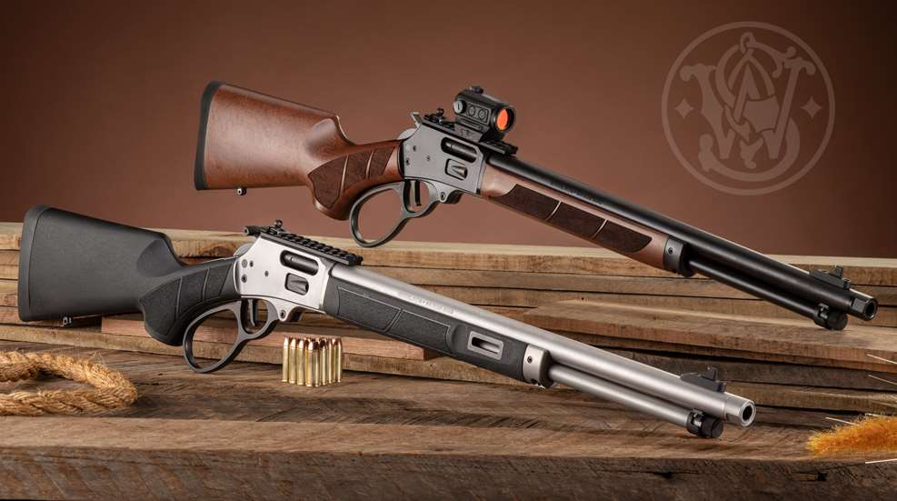 Smith & Wesson’s Model 1854 Lever-Action rifles side-by-side comparison wood stock synthetic stainless steel shown on wood table with rope ammunition