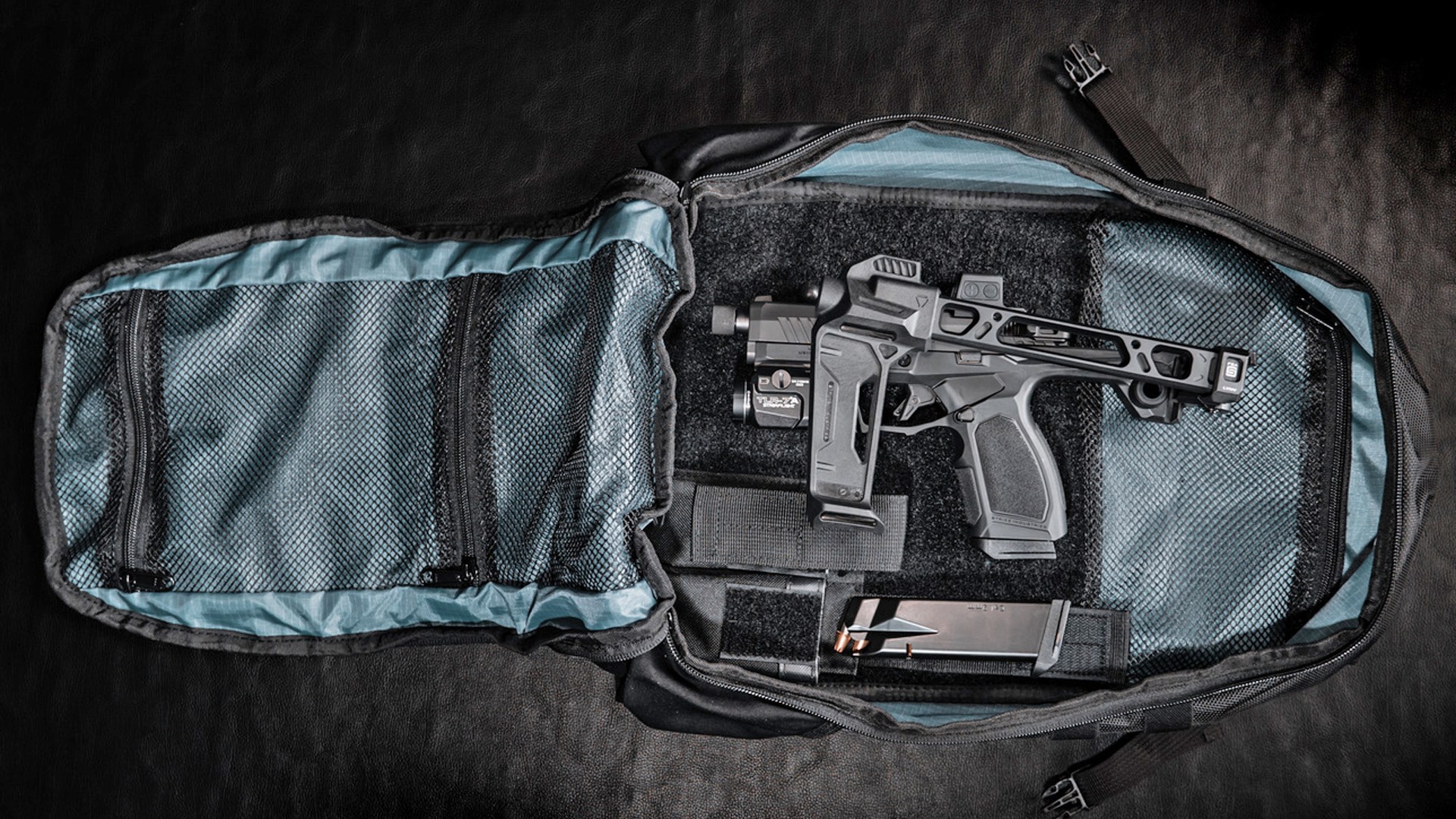 Taurus GX4 Strike Bravo sitting in an unzipped carry pack next to a loaded magazine.