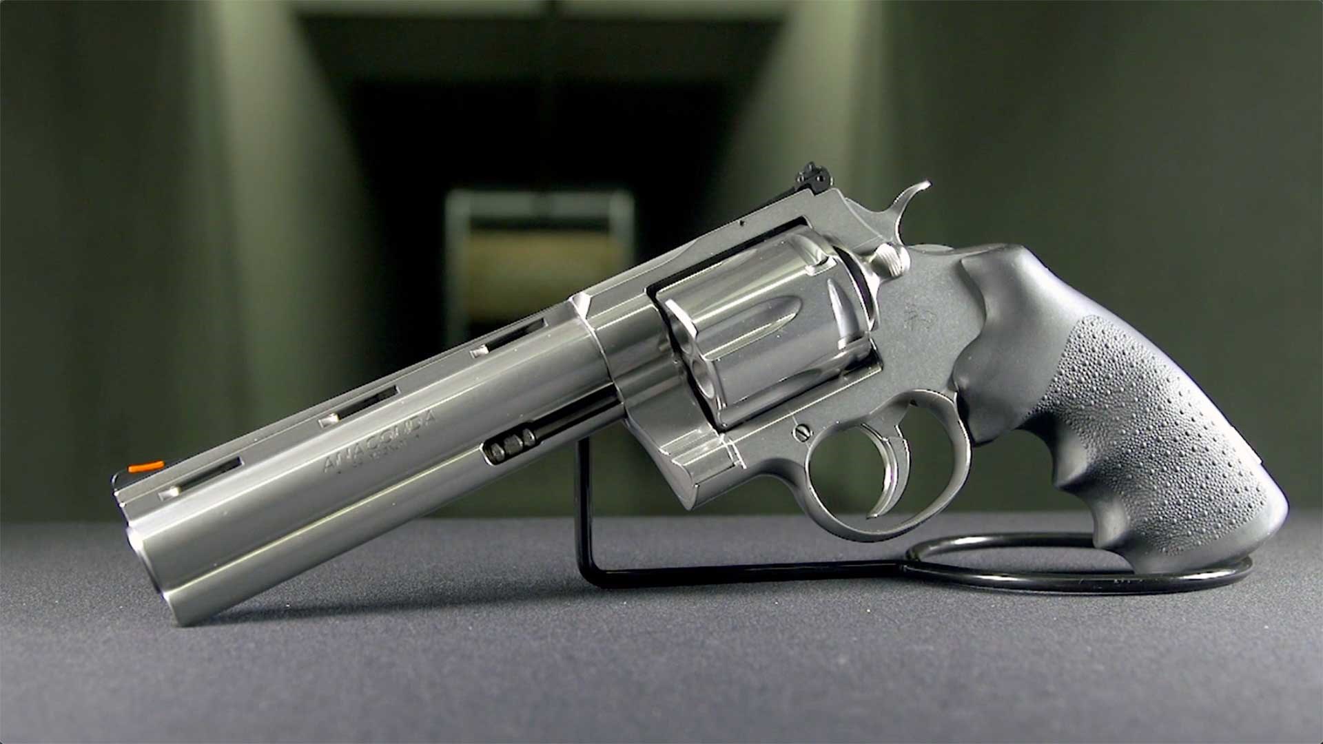 Left side of the Colt Anaconda .44 Mag. revolver shown with a dark range target in the background.