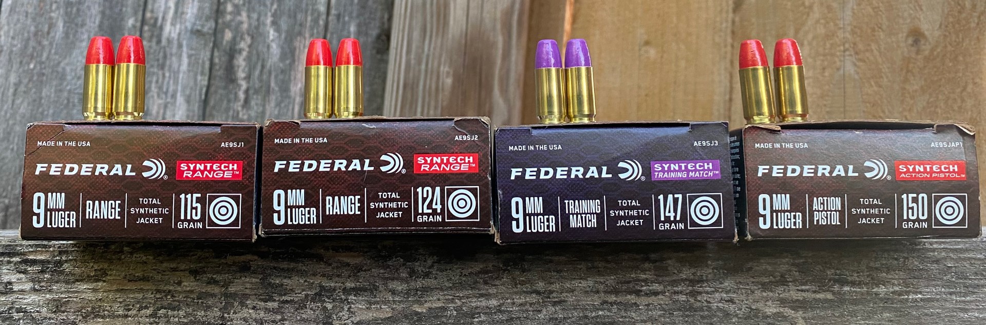 Four boxes of Federal Syntech ammunition with bullets and wood background
