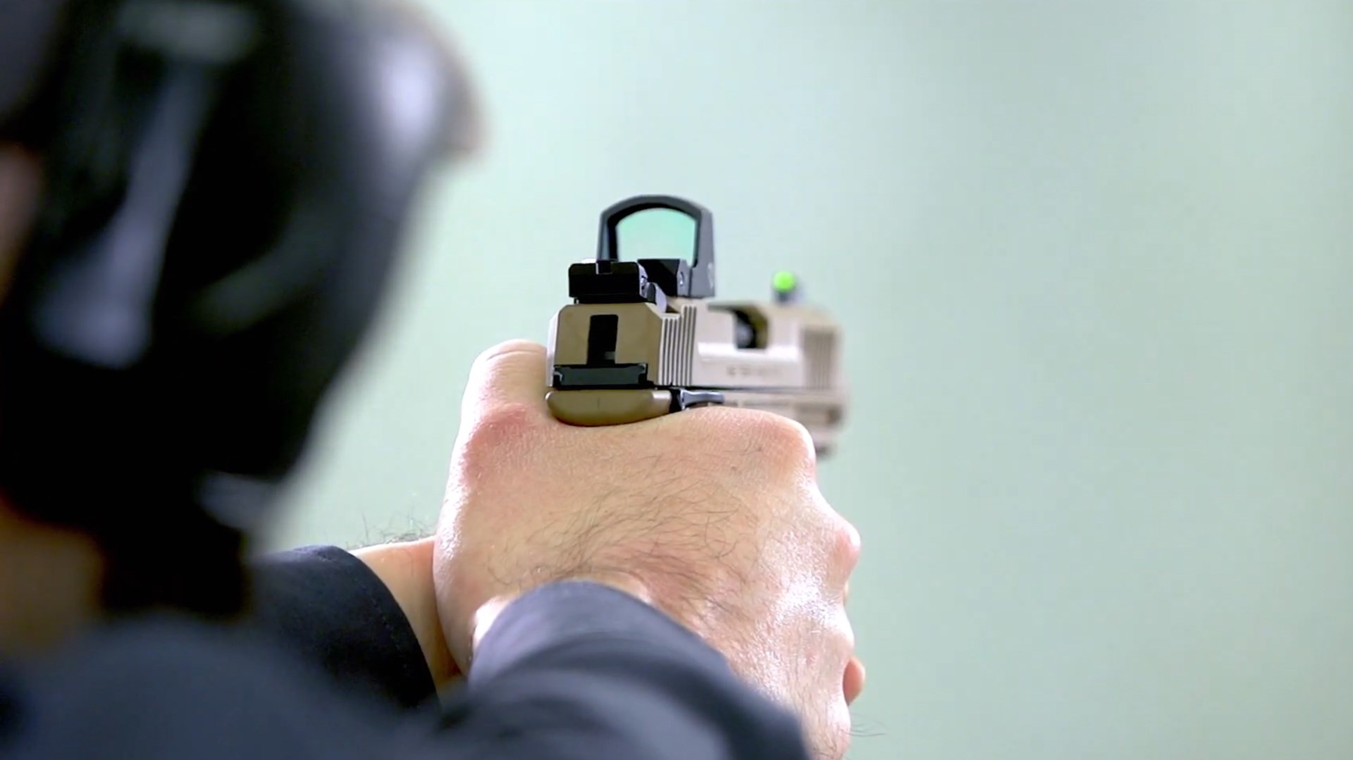 Rear view of handgun pistol being fired indoors
