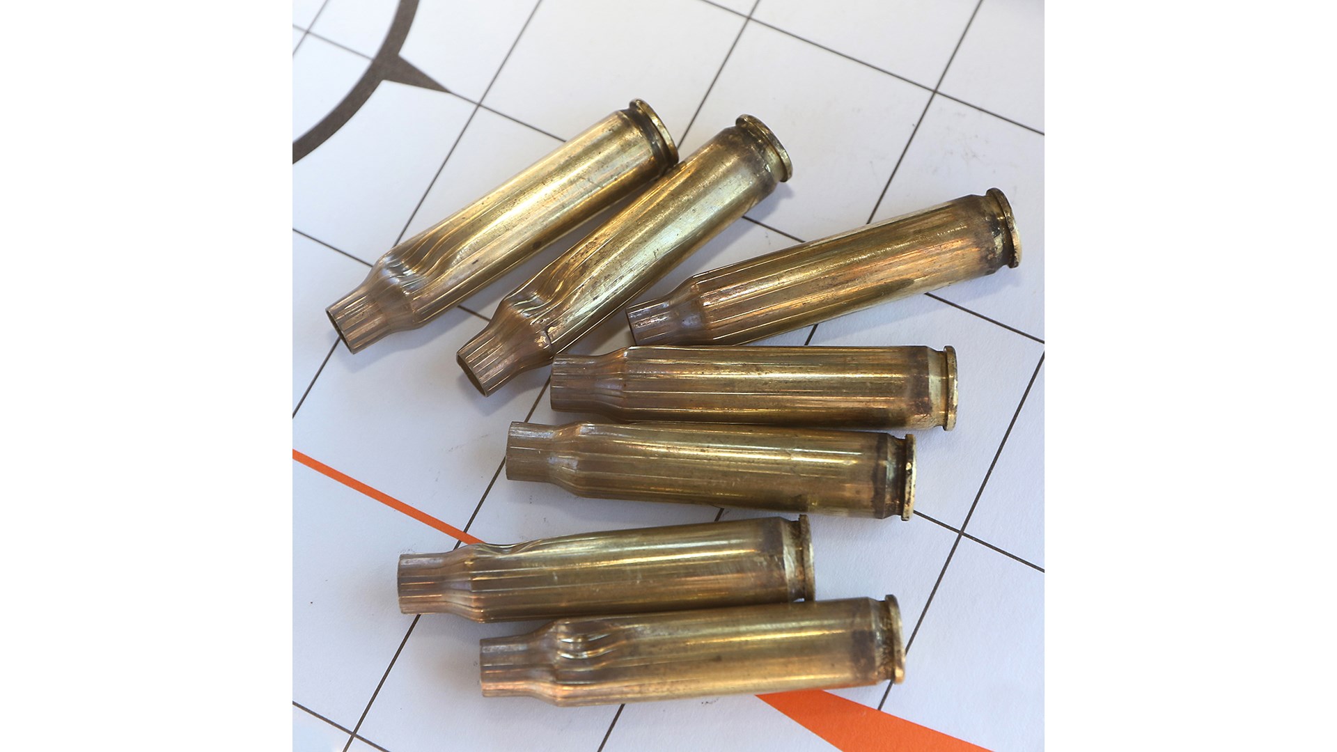Brass-colored rifle cartridge cases without bullets, once-fired shown on target closeup view