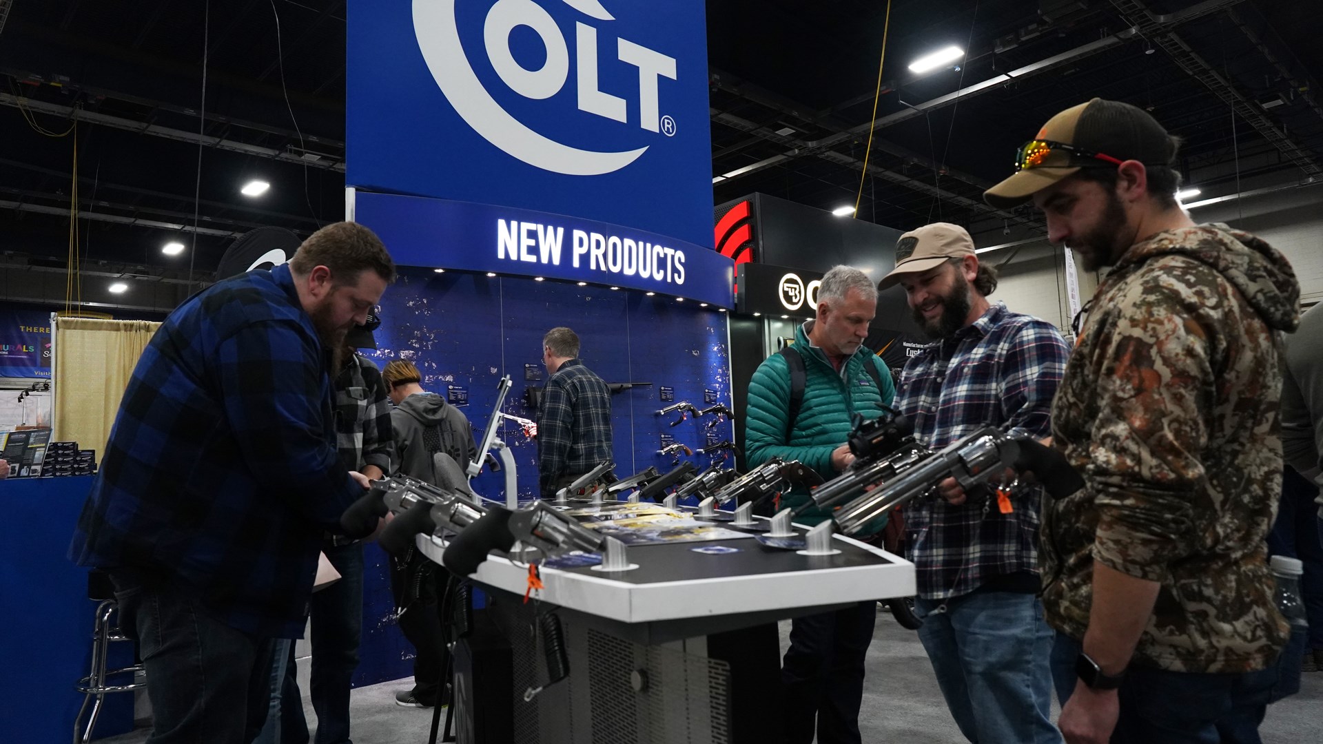 people gathered at COLT Firearms new products booth at great american outdoor show