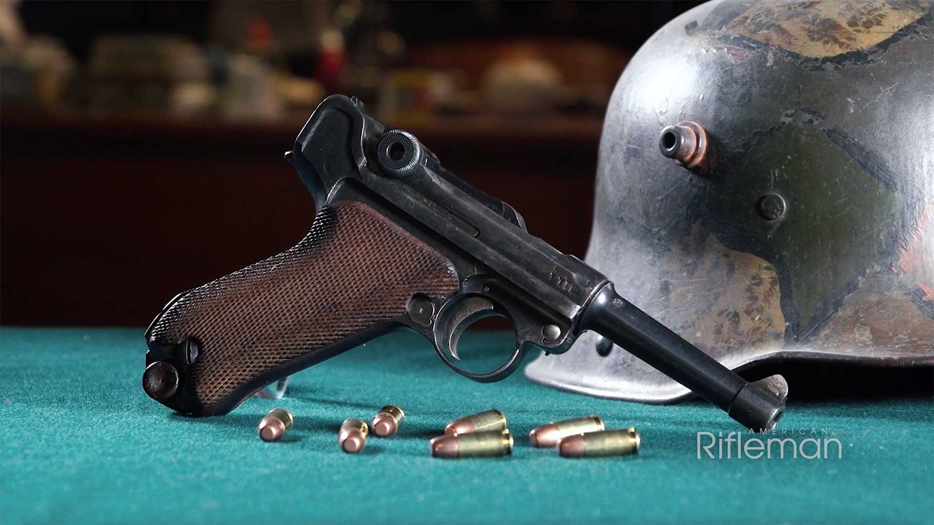 Right side of the P08 Luger pistol with a German steel helmet behind it.