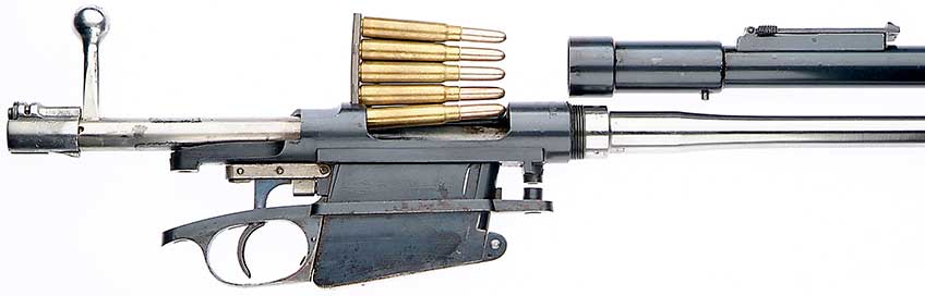 Right-side view of bolt-action rifle disassembled on white background with bolt withdran and ammunition clip with rounds inserted.