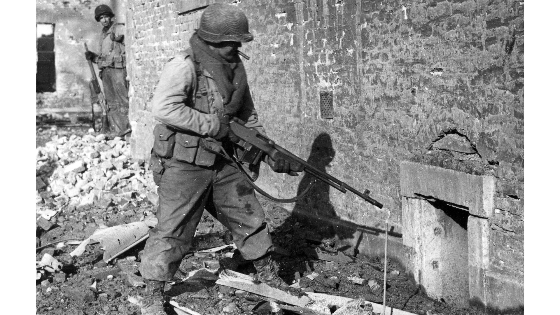 World War II Julich, Germany stone building U.S. BAR gunners with guns heading toward entrance window