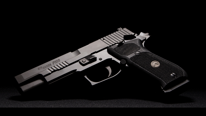 Left-side view of SIG Sauer P220 Legion 10 mm pistol on black background.