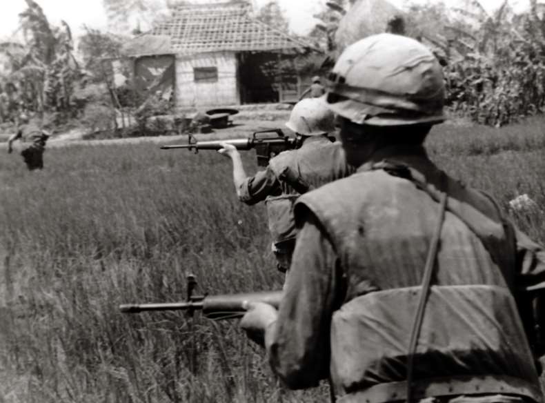 Marines suppress VC positions with their M16 rifles in 1968.