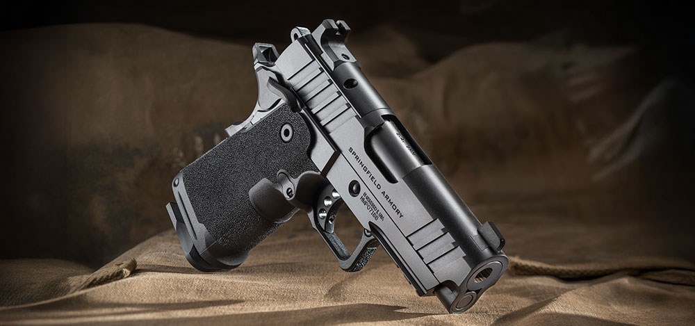 Springfield Prodigy 3.5" Compact right-side view dynamic angle black pistol double-stack 1911 9 mm gun foreground military canvas backdrop