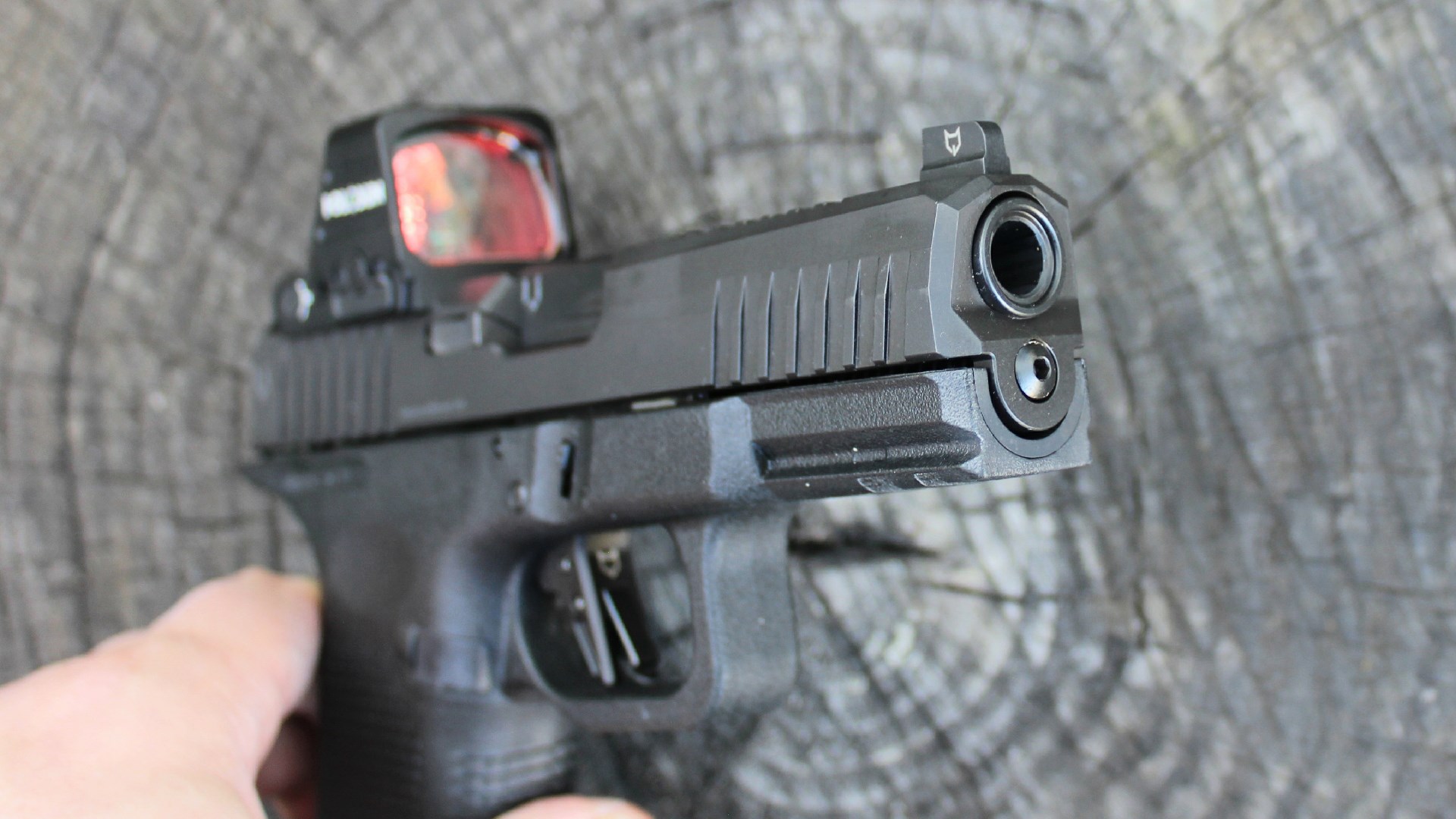 Forward view of Lone Wolf Timberwolf 19X pistol 9 mm barrel muzzle crown slide serrations shown in hand with wood background