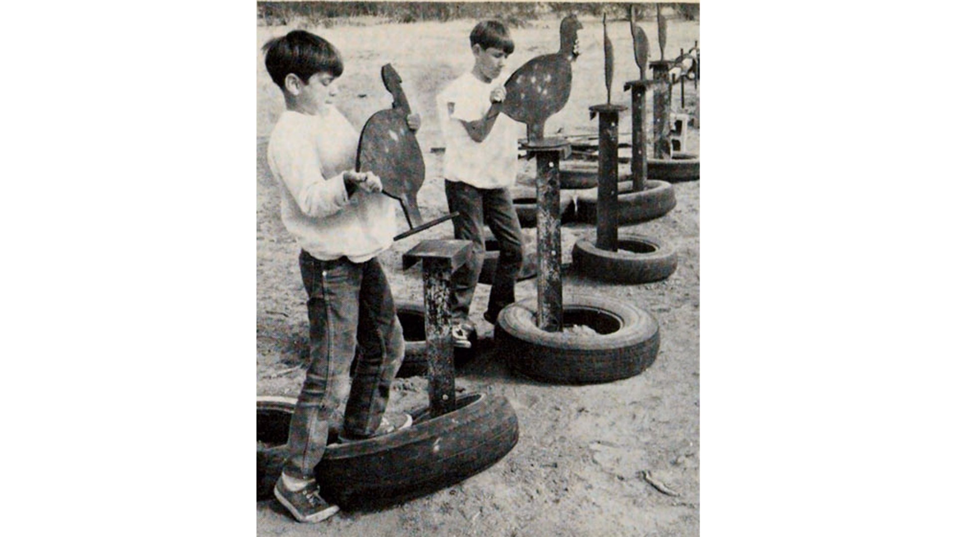 Youth vintage image boys hanging steel chicken targets tires outdoors
