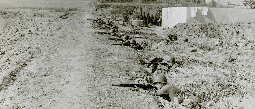 United States Army soldiers aim their M1 Garand rifles