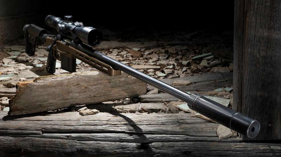 Bolt-action rifle shown with spotlight and suppressor silencer muzzle device attached