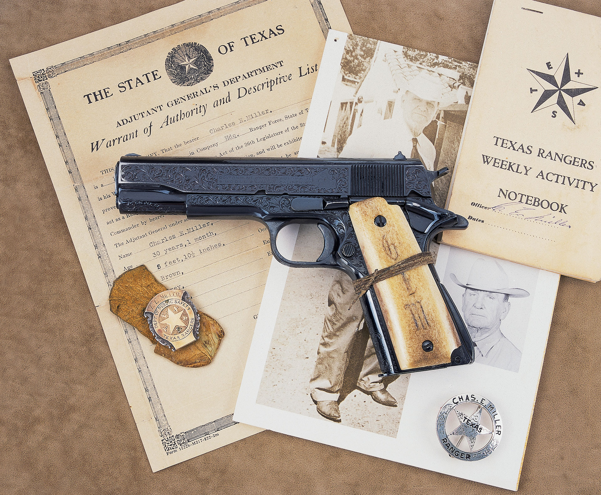 M1911A1 reblued with dark finish and light colored grips on top of documents associated with the pistol.