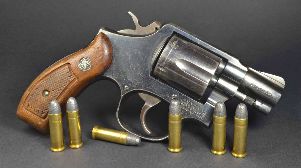 Smith & Wesson J-Frame revolver right-side view shown with .38 Special ammunition cartridges
