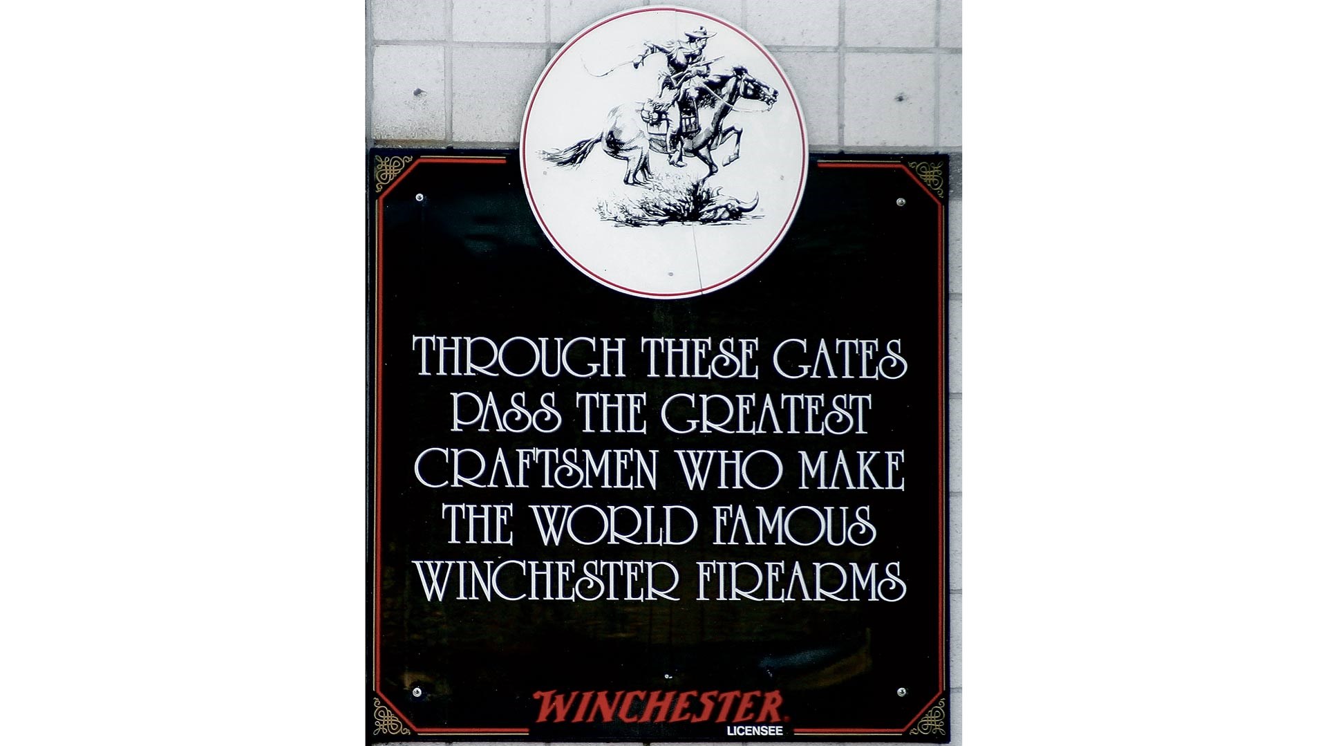Winchester signage stating: Through these gates pass the greatest craftsmen who make the world famous winchester firearms.