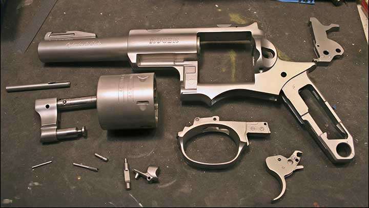 left-side view ruger revolver redhawk gun disassembled on table parts pieces components spread