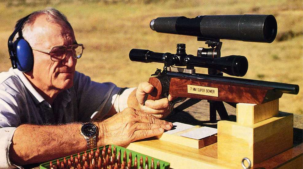 Don Bower at shooting bench outdoors with T/C Contender pistol and 7 mm Super Bower ammunition