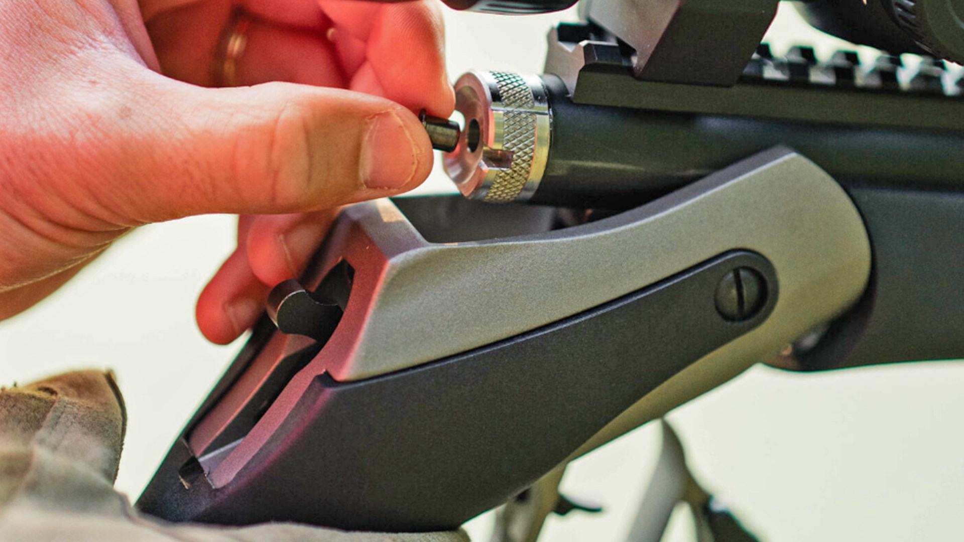 Man placing a shotgun primer in the breech of the Triumph in-line muzzleloader.