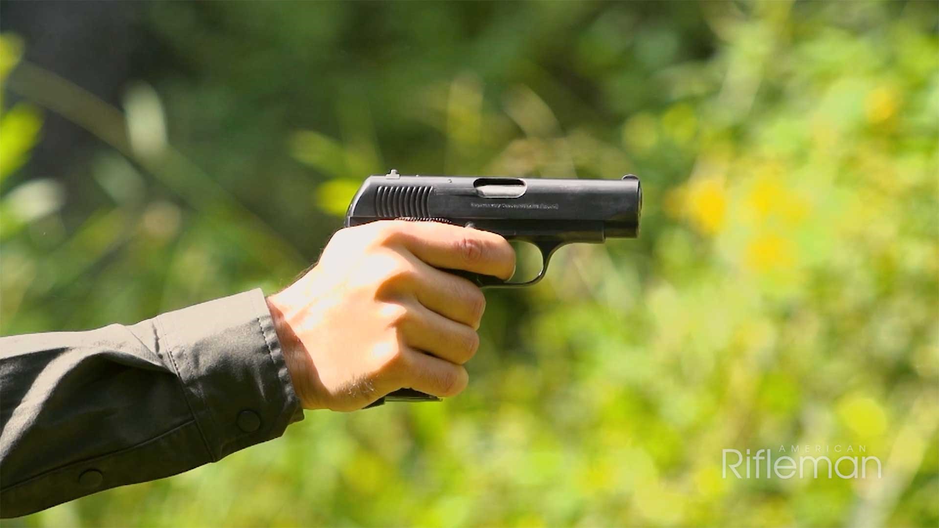 Man shooting a Spanish Ruby pistol on an outdoor range.