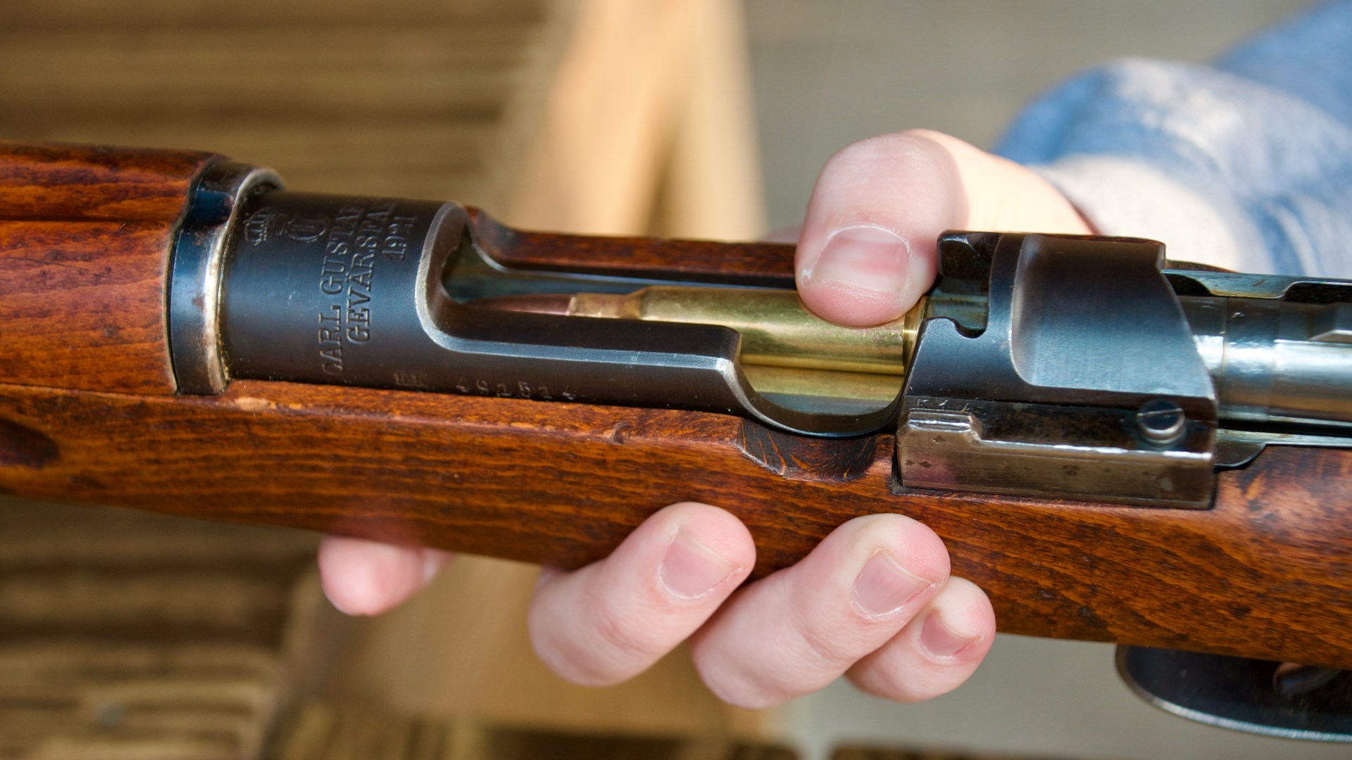 swedish mauser m1896 bolt-action rifle loading ammunition hands wood metal rifle gun