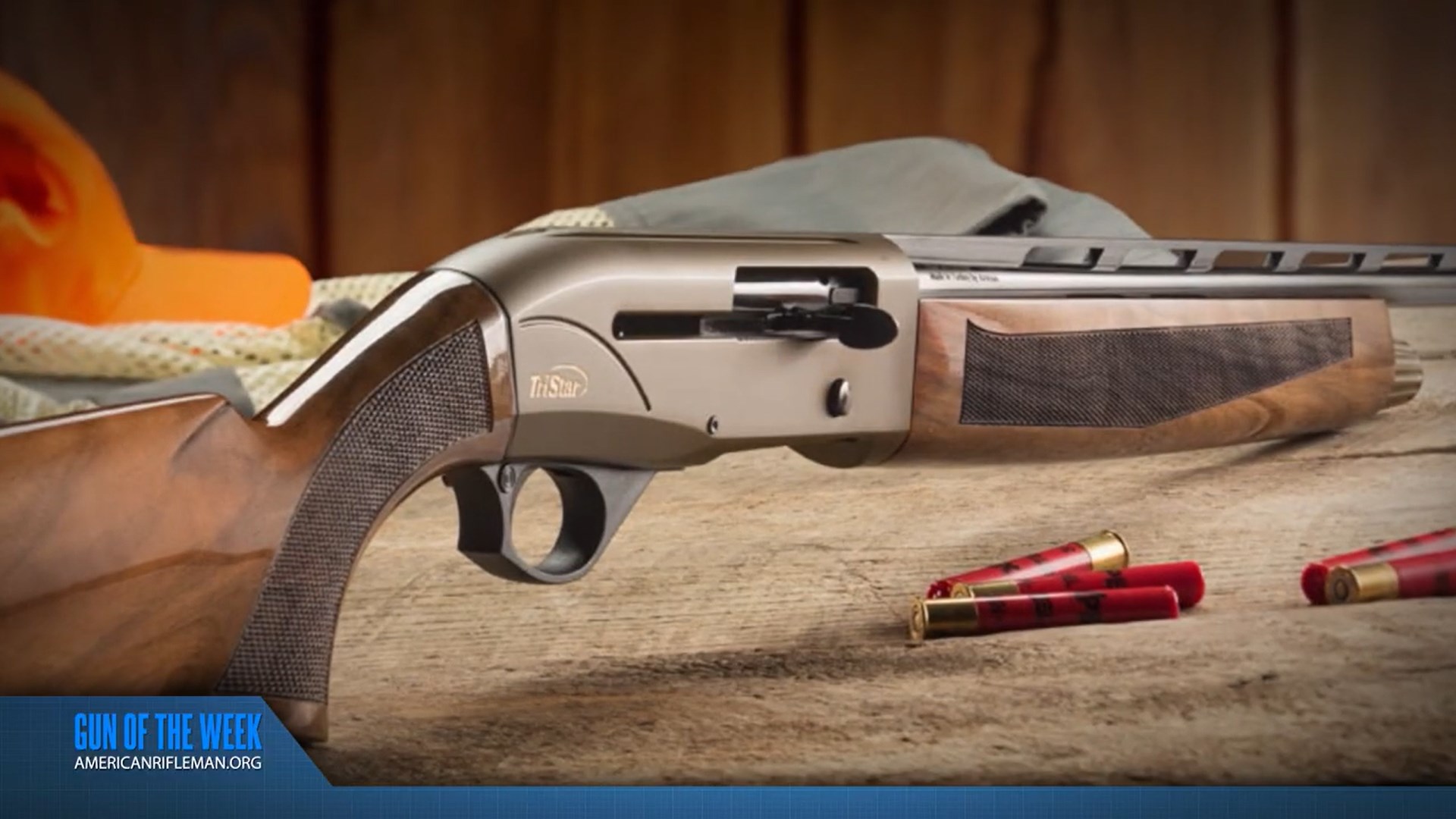 TriStar Arms Viper G2 Bronze in .410 bore shotgun shown on wood table with shotshells orange hunting cap background wood stock gun right side angled view
