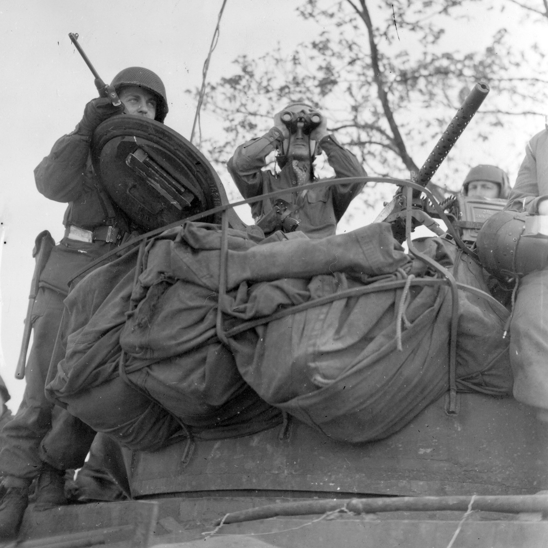 A Sherman tank with a Browning M1919A4 (on an M2 tripod) added to the turret top for the commander to use. The tank commander (center) carries his M1911 pistol in a shoulder holster.