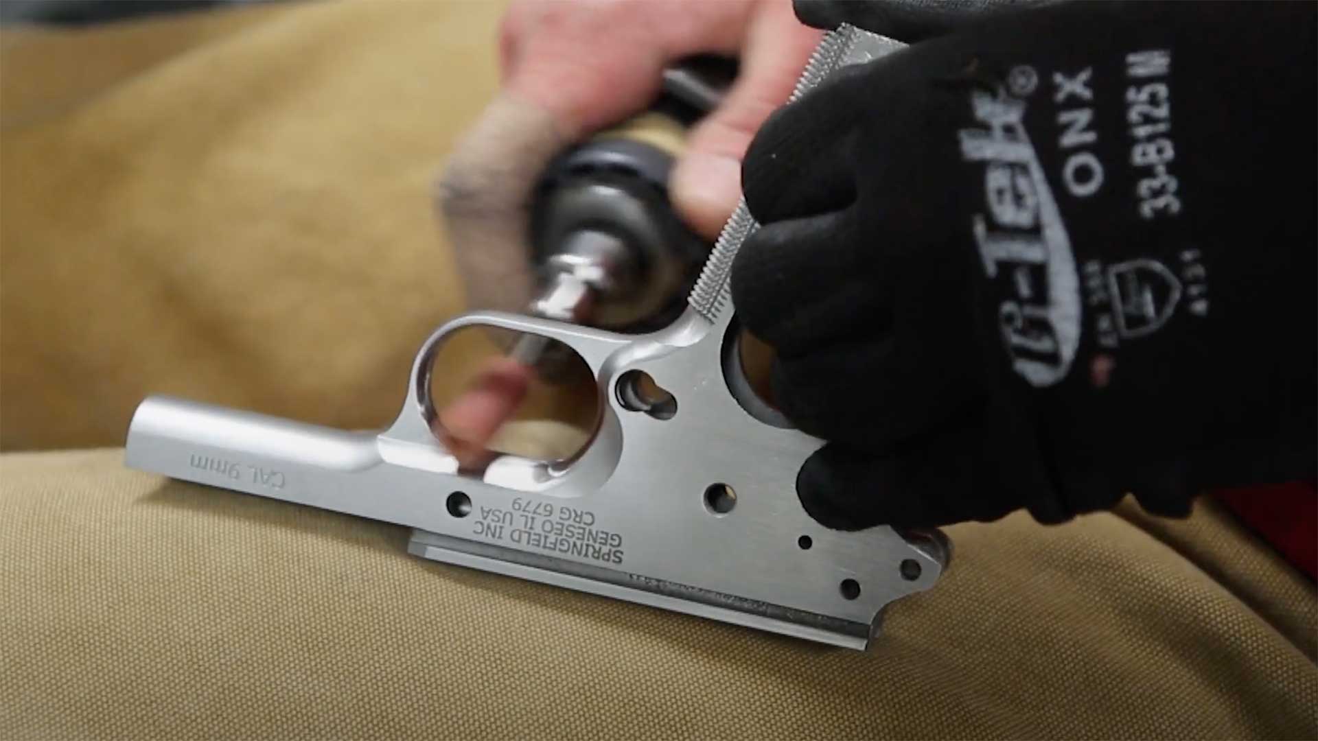 A worker at the Springfield Armory Inc. Custom Shop polishing the receiver of a 1911.