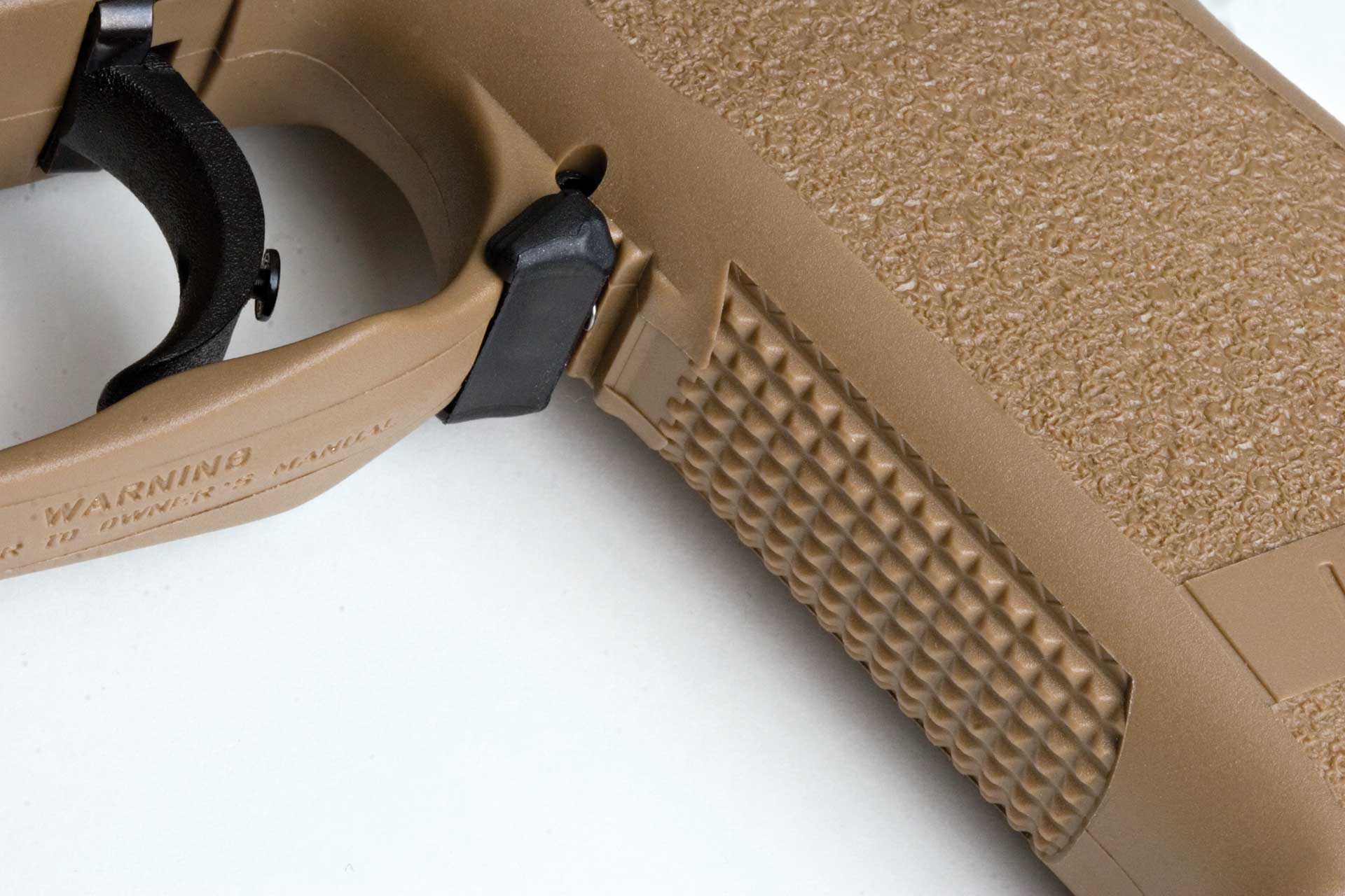 H&K USP Tactical handgun pistol frame tan plastic detail closeup trigger grip texture