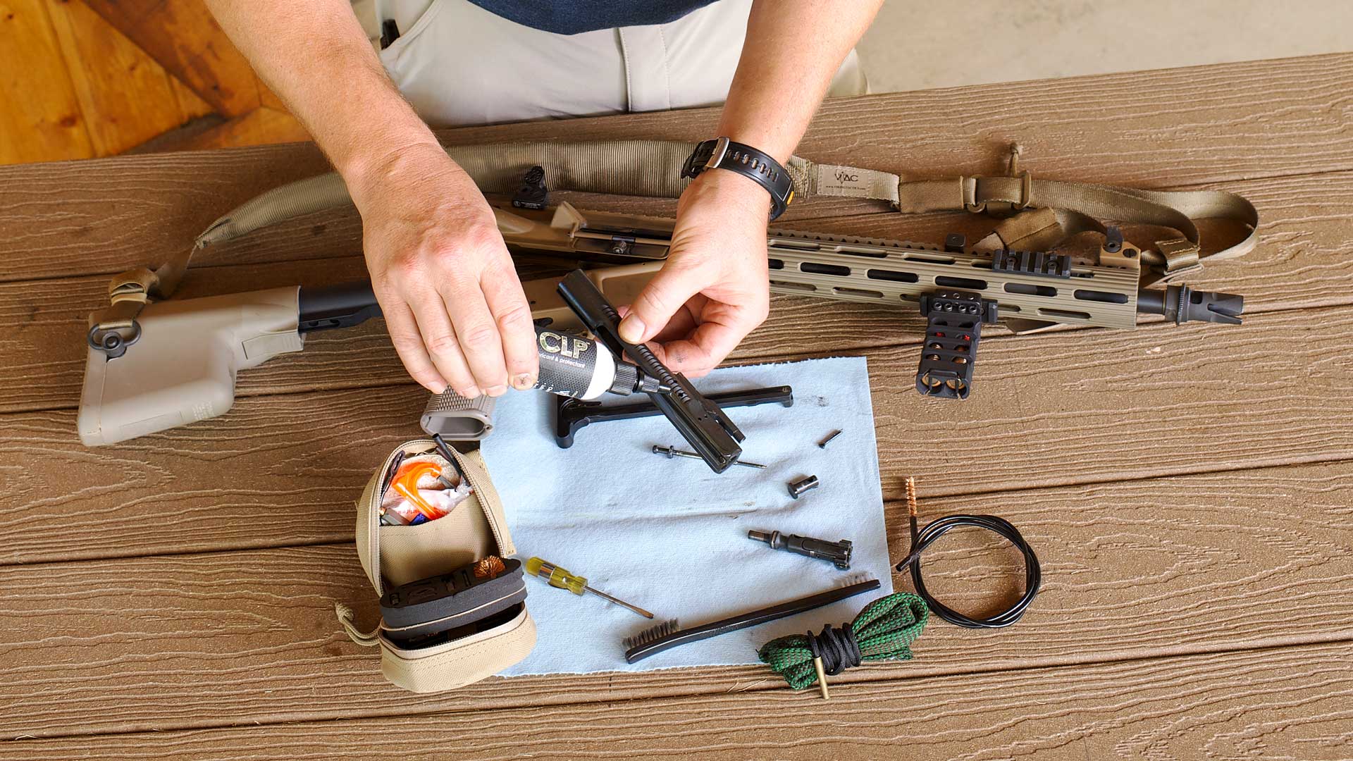 rifle parts lube hands disassemble metal assembly gun table