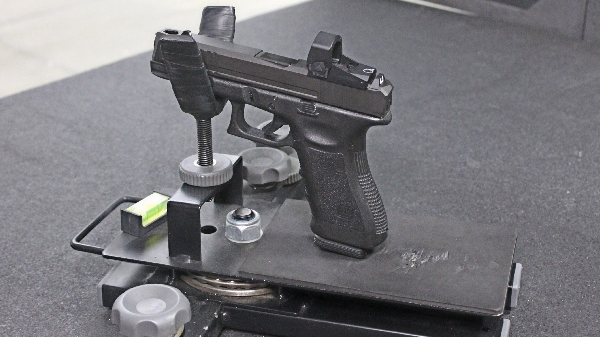 Custom Glock pistol in rest on bench at shooting range