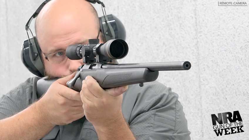 man wearing ear muffs glasses shooting rifle