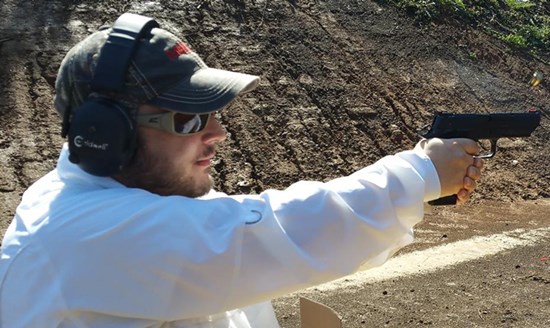 man wearing white shirt shooting pistol handgun outdoors