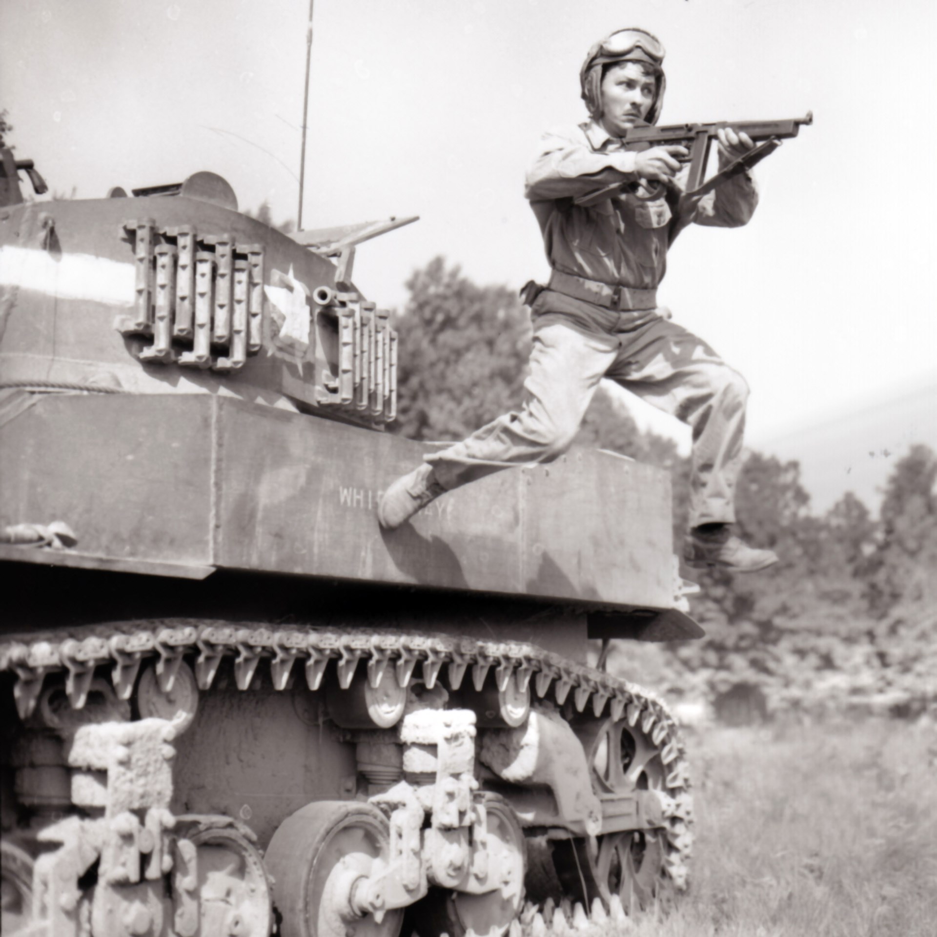 A M5 Stuart tank commander leaps off his vehicle with M1A1 Thompson SMG in hand. Stateside training, 1943.