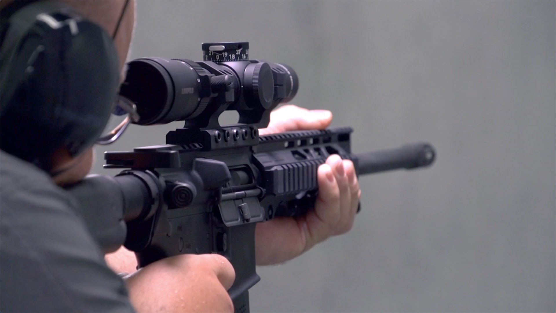 Man in a gray shirt pointing the Rock River Arms Assurance Carbine on a range.