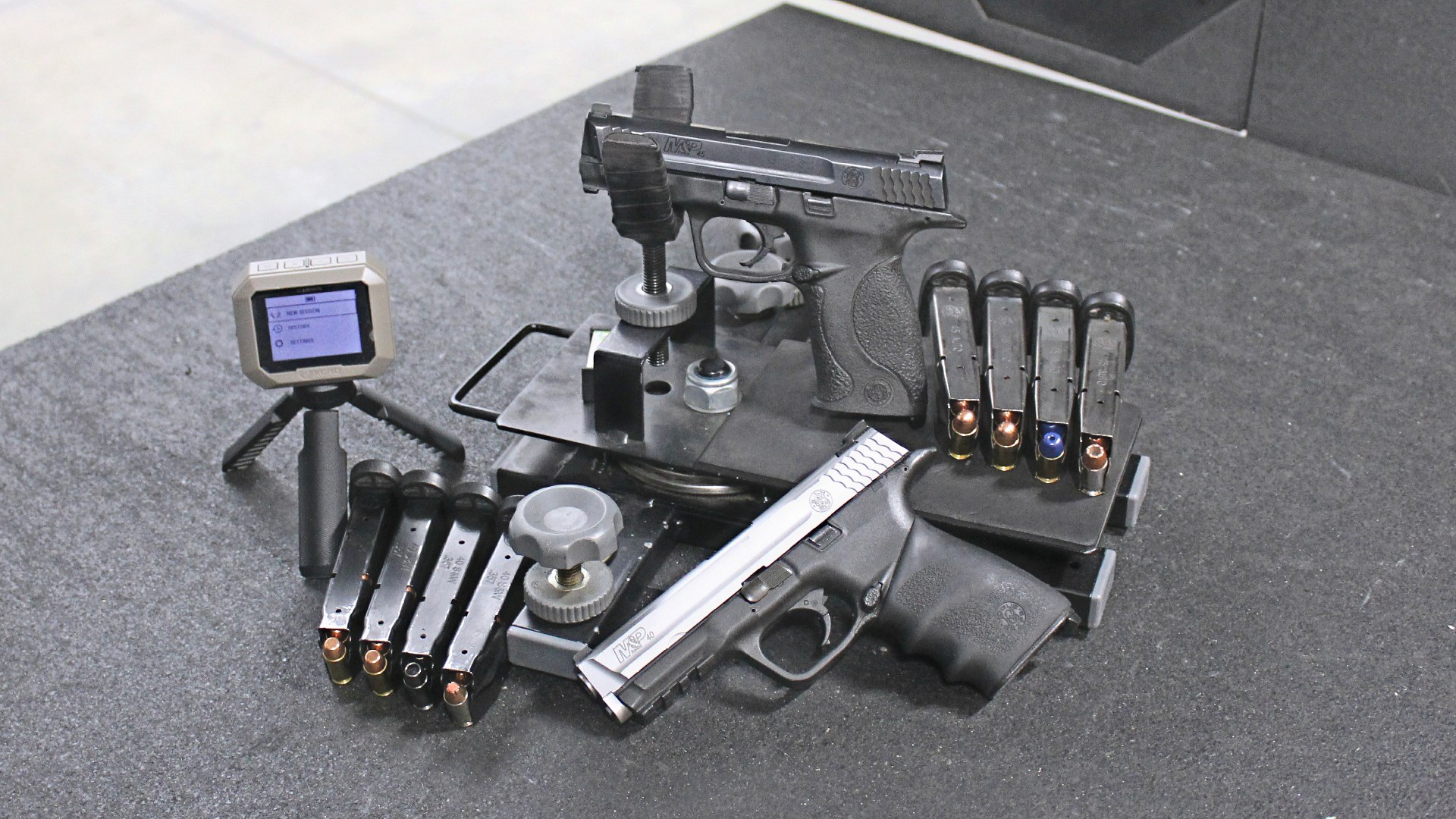 Smith & Wesson M&P 45 used gun in cradle with magazines M&P 40 two-tone and Garmin chronograph indoor shooting range bench