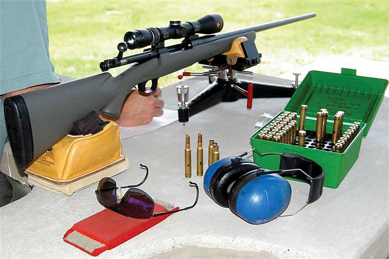 Bolt-Action rifle on range bench with bullets and gear