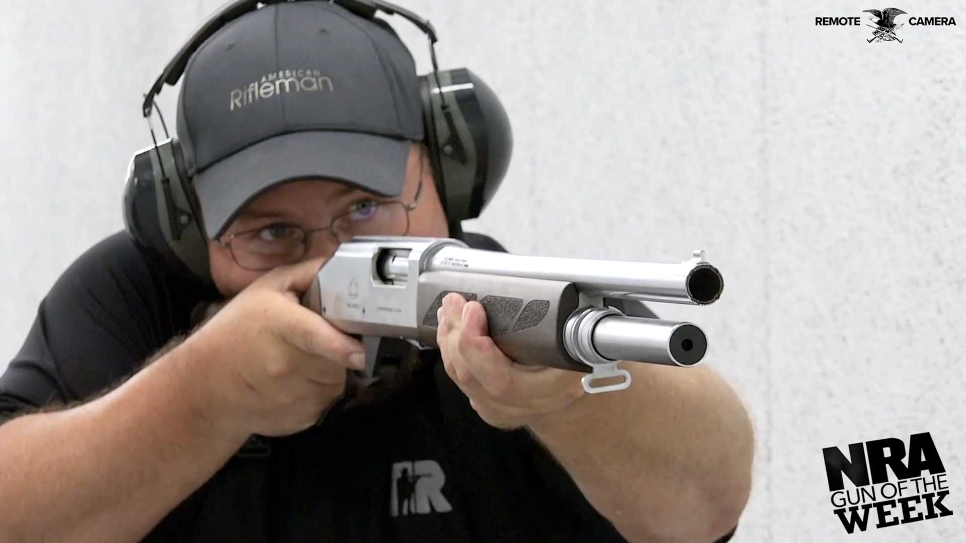 man gun shooting silver metal ballcap black shirt