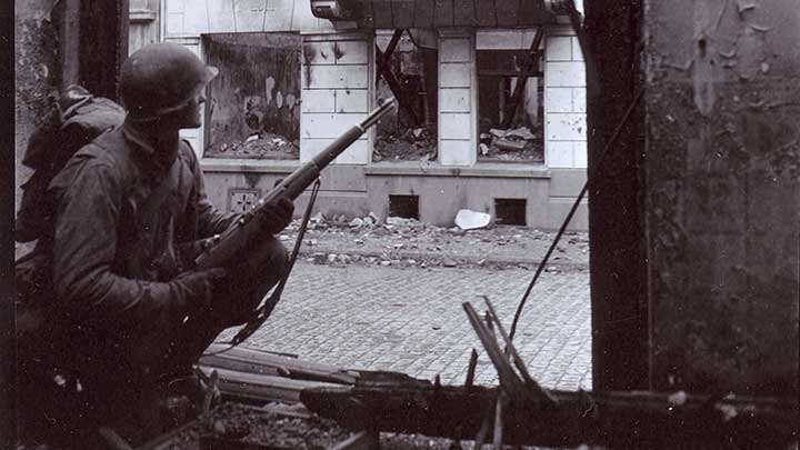 A G.I. of the 13th Infantry Regiment on guard for snipers with his M1 Garand rifle.