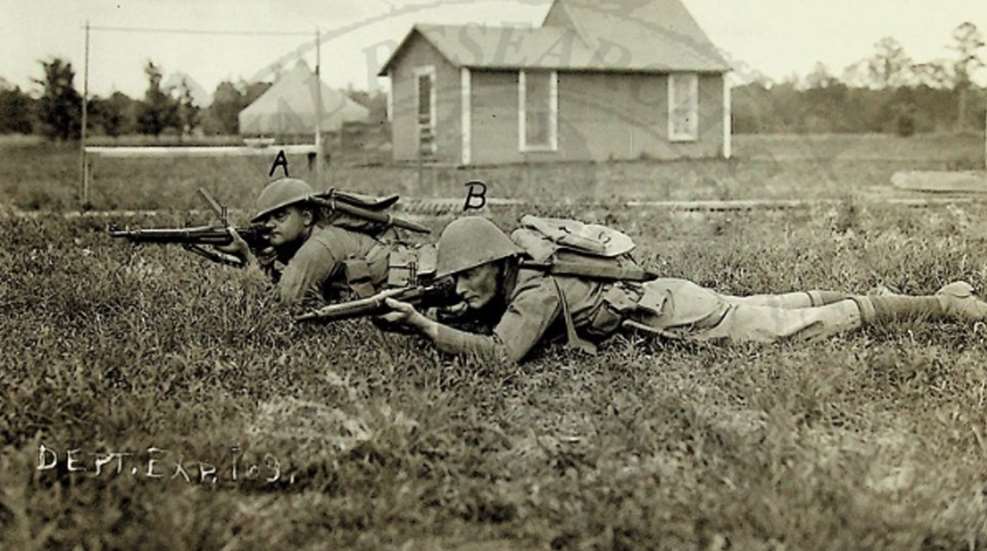 Two soldiers demonstrating a firing position with and without the Pedersen Device mounted.